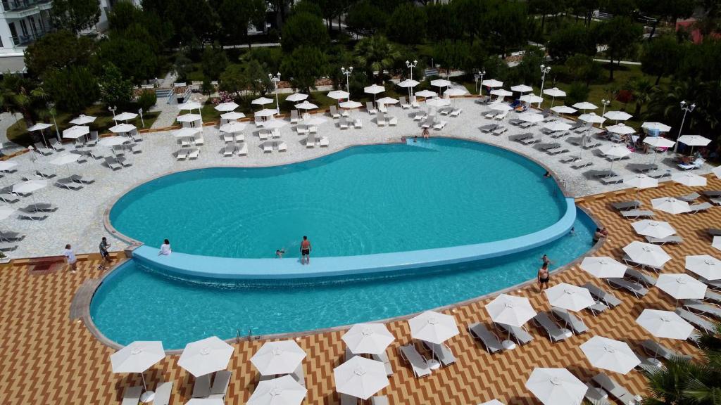 an overhead view of a swimming pool with chairs and umbrellas at Vila Inheritor in Shëngjin