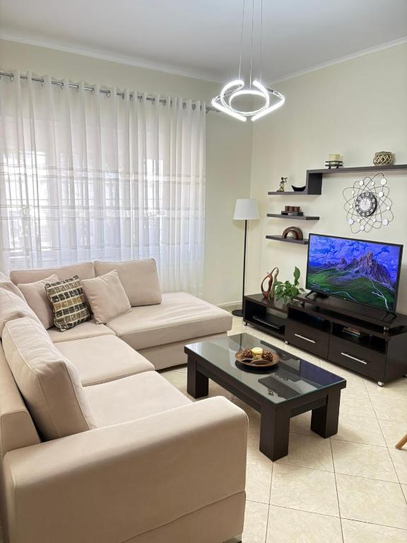 a living room with a couch and a tv at Sofia's modern apartment in Gjirokastër
