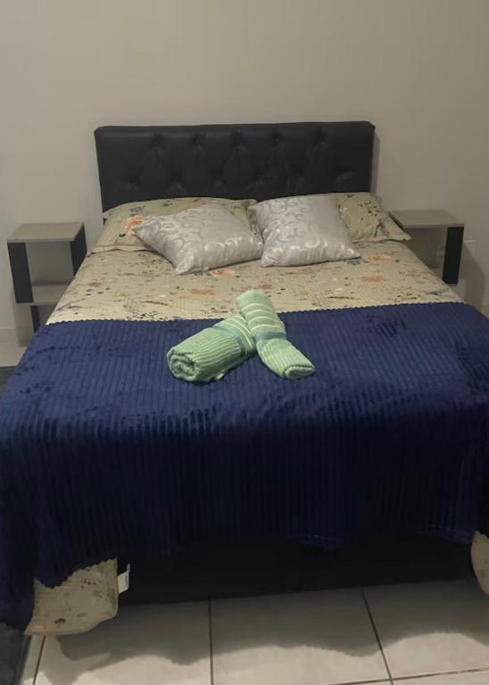 a pair of green shoes sitting on a bed at Sua casa longe de casa in Anápolis