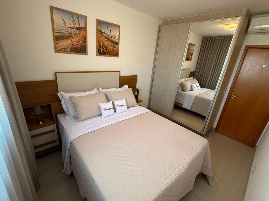 a bedroom with a large bed and a mirror at Vista Panorâmica • Premium in Palmas