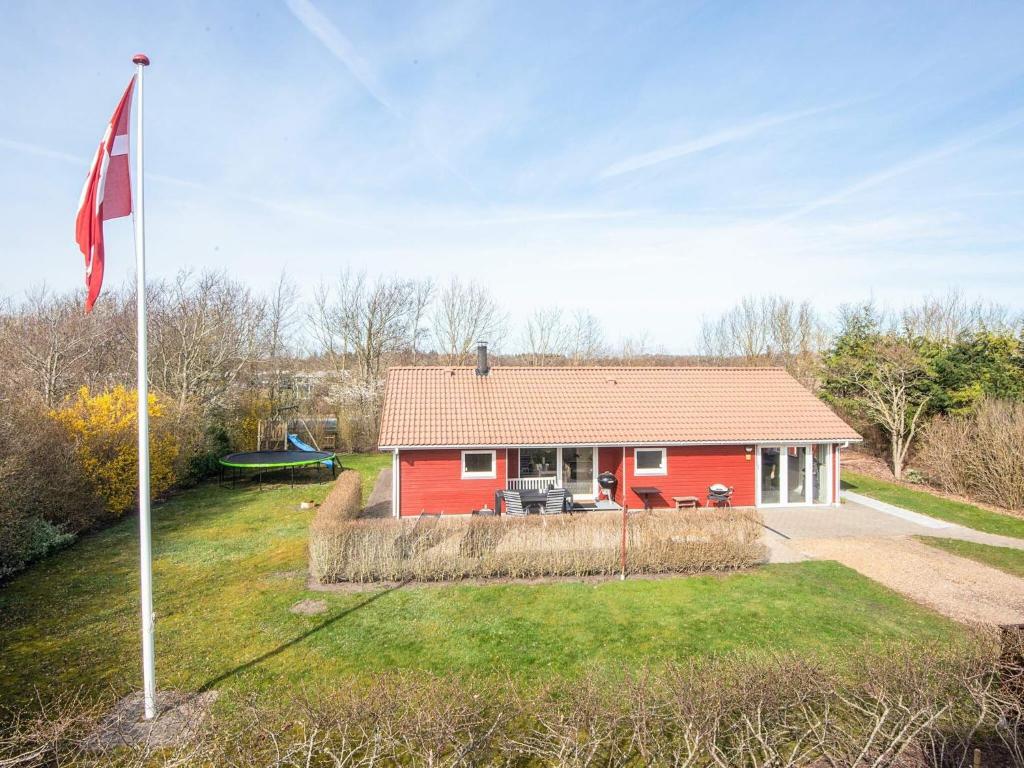 a red house with a flag in front of it at 6 person holiday home in Tarm in Tarm