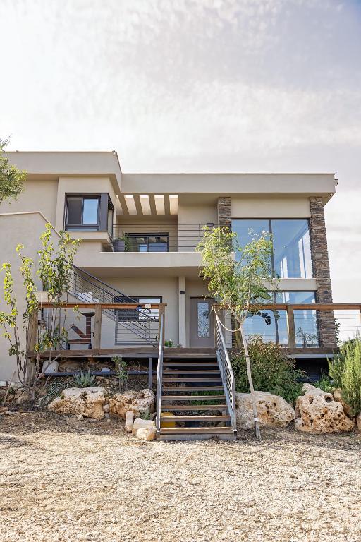 a house with a staircase in front of it at נוף המצוק בגליל in Even Menahem