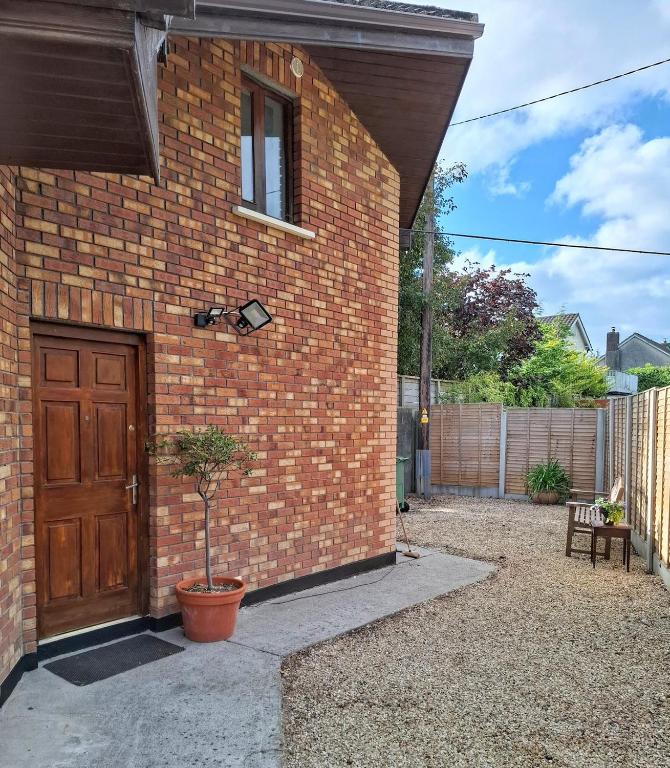 a brick building with a wooden door and a potted plant at Sea Loft in Shankill