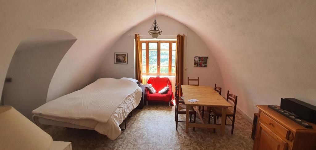 a bedroom with a bed and a table and a chair at Gite des pecheurs, Gorges du Tarn in Mostuéjouls