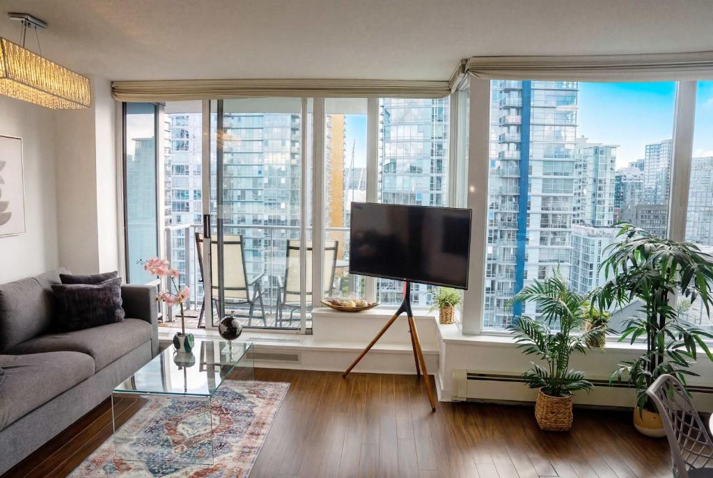 a living room with a tv and a large window at Gorgeous Unit with City Views in Vancouver