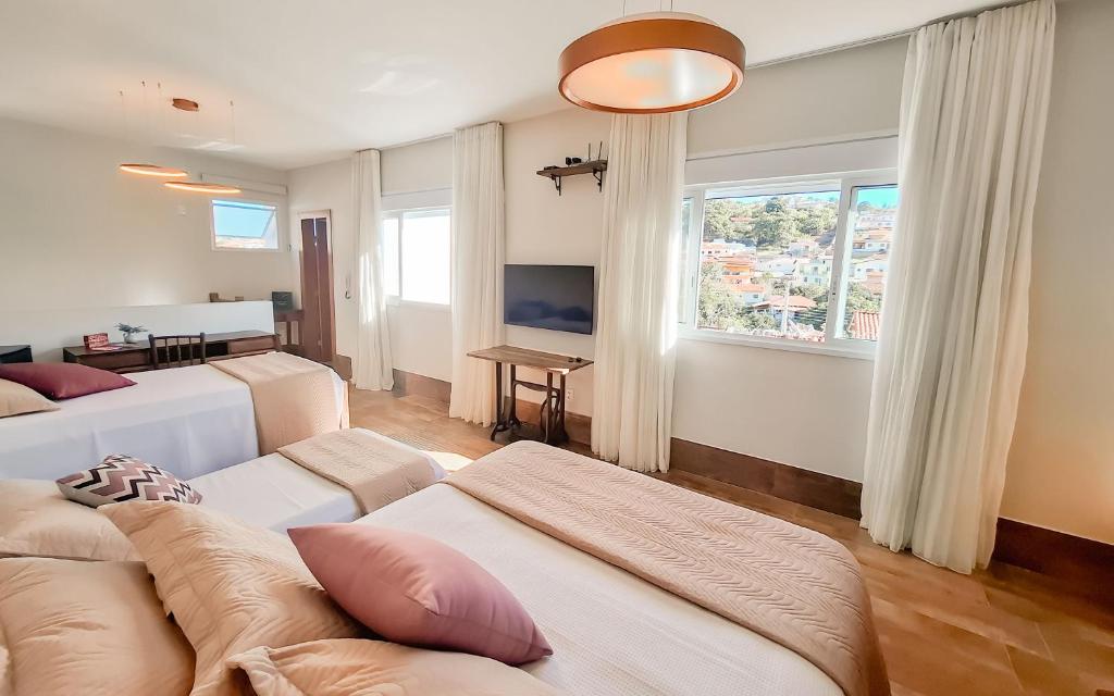 a living room with a couch and a large window at Casa Duplex c/ suíte cozinha completa e ventilador in Diamantina