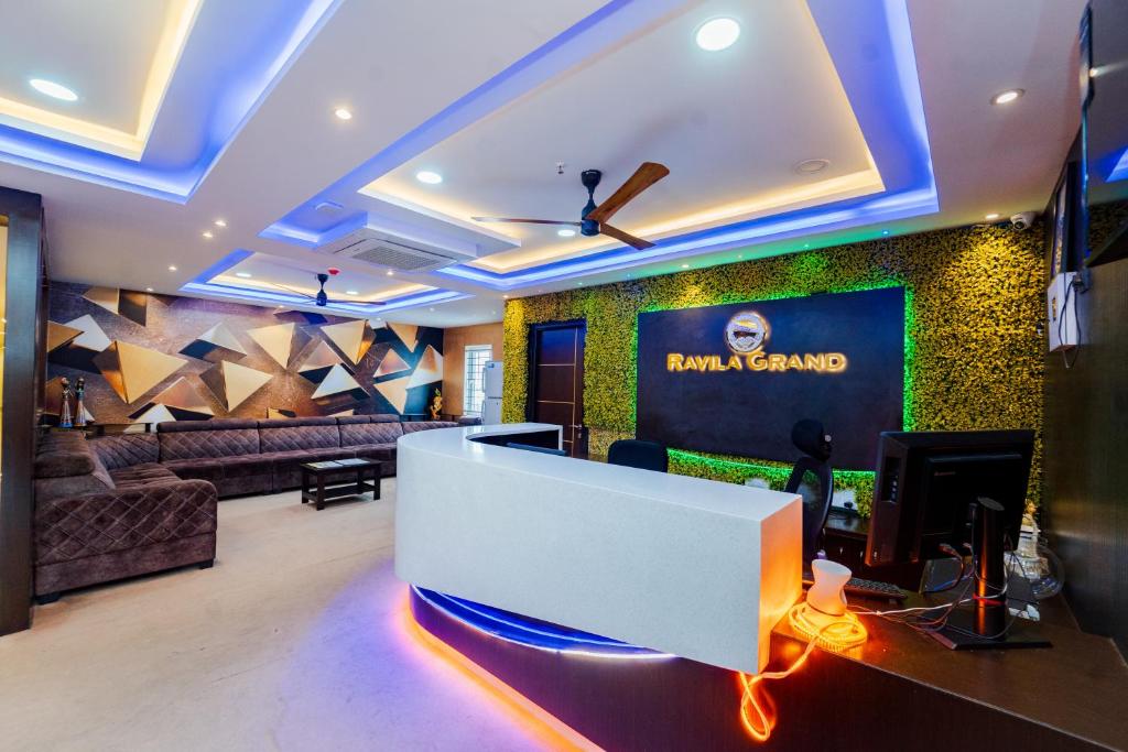 a living room with a tv and a couch at Ravila Grand Hotel in Lingampalli
