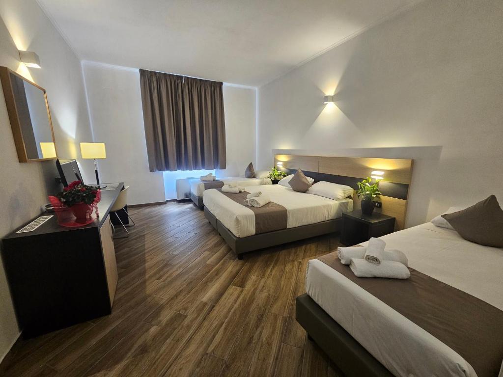 a hotel room with two beds and a television at Hotel Alba Roma in Rome
