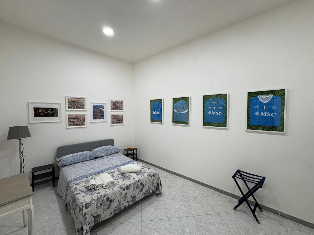 a bedroom with a bed and some pictures on the wall at B&B Napul'è in Naples