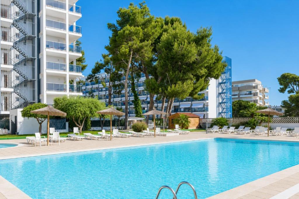 an image of a swimming pool with chairs and umbrellas at Salou Pacific Rentalmar in Salou