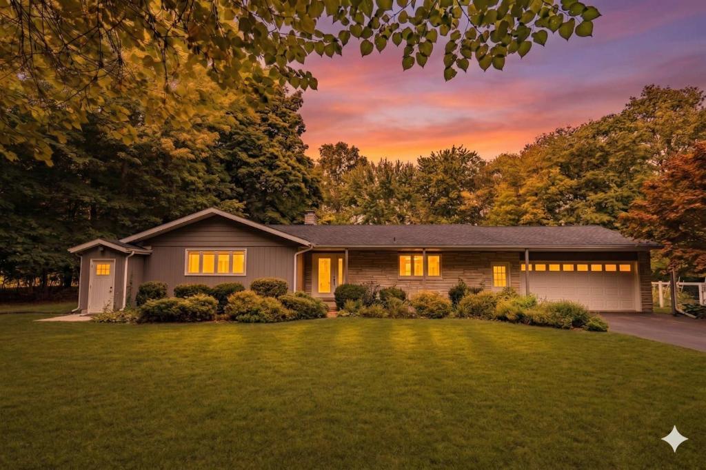 a home with a large yard with a house at Stunning Ranch in the woods in Berrien Springs
