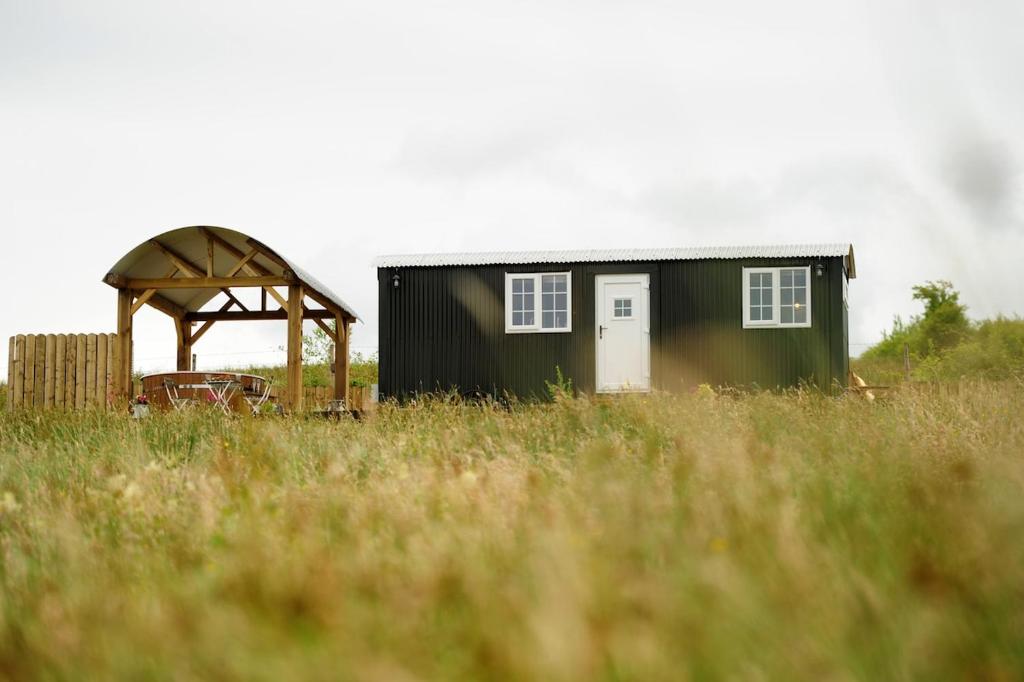 a small house and a gazebo in a field at The Barraghan in Derrygonnelly