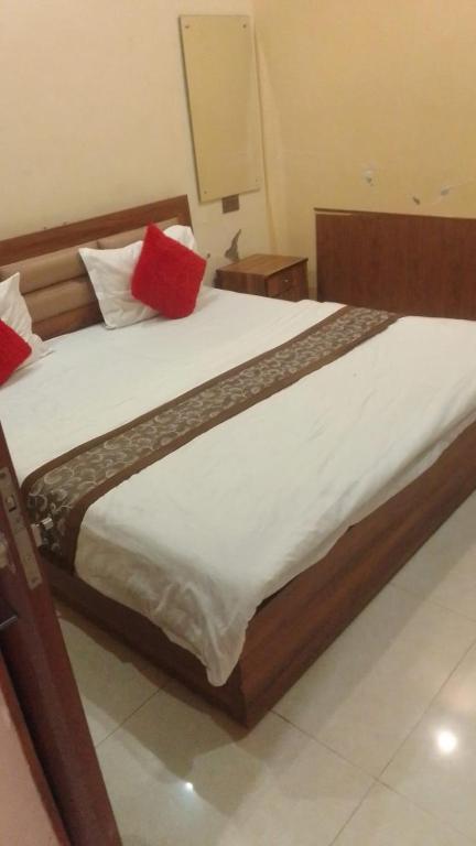 a large bed with red pillows on top of it at guest house honey haldwani in Haldwāni