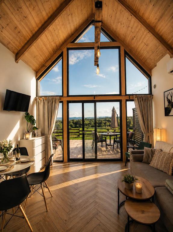 a living room with a large window and a couch at Osada Przejrzysko in Jordanów