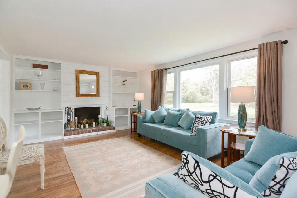 a living room with blue furniture and a fireplace at Just For the Halibut in Rockport