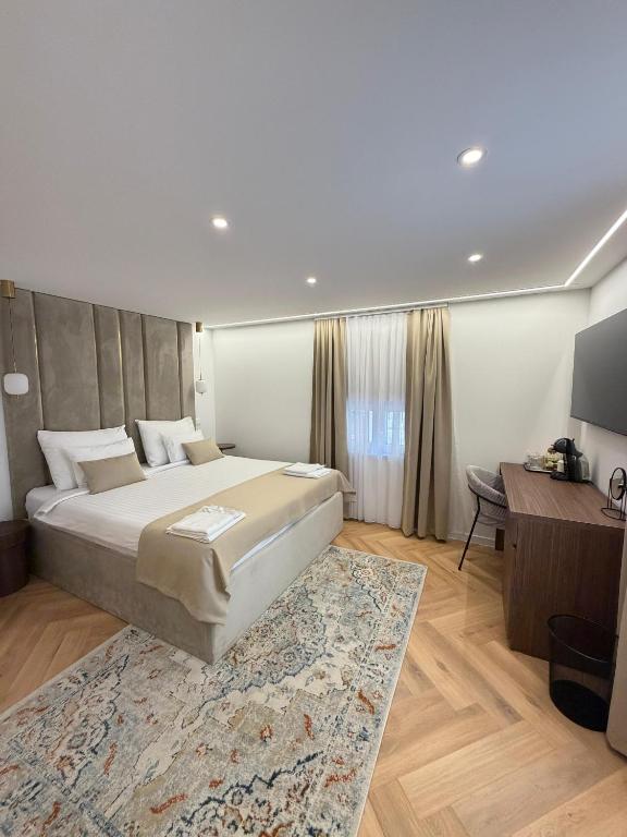 a bedroom with a large bed and a desk at The Elysium Rooms in Makarska