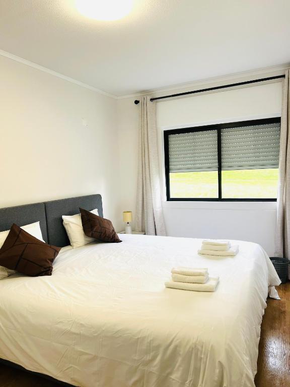 a bedroom with a white bed with towels on it at Casa Basáltico in Horta
