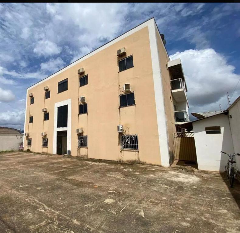a large building with a parking lot in front of it at Prédio Solar da Serra in Parauapebas