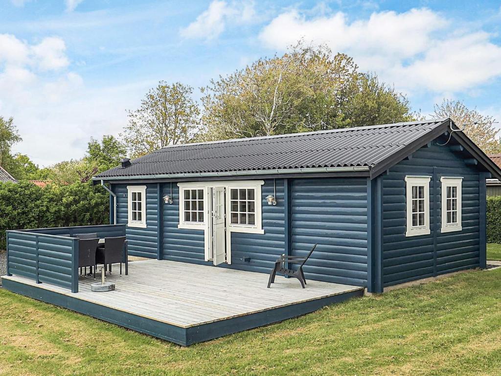 a blue shed with a deck in a yard at 4 person holiday home in Assens in Assens