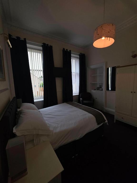 a bedroom with a large bed and a lamp at Waverley Hotel in Bonnyrigg