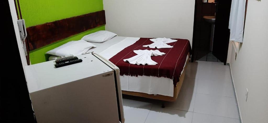 a bedroom with a bed with a red and white blanket at Pousada dos Pássaros Pipa in Pipa