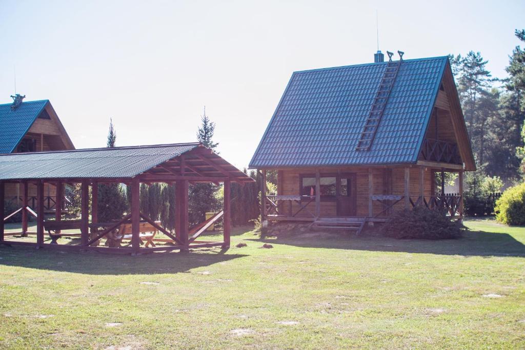 a large wooden house with a gambrel roof at Pas Kaziuką namukas in Palūšė