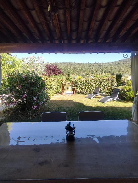 a table with chairs and a view of a yard at Pays des Senteurs in Saint-Ferréol-Trente-Pas