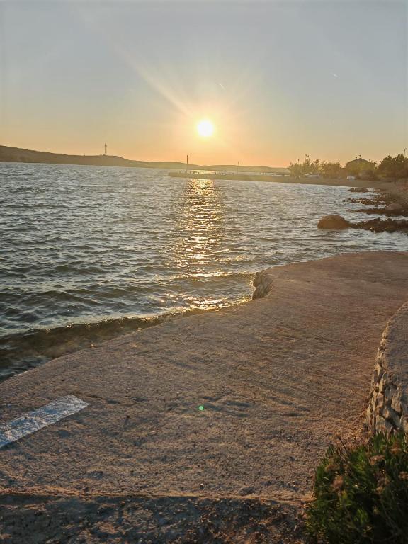 a sunset on the shore of a body of water at Apartment Cherry s pogledom na more in Dinjiška