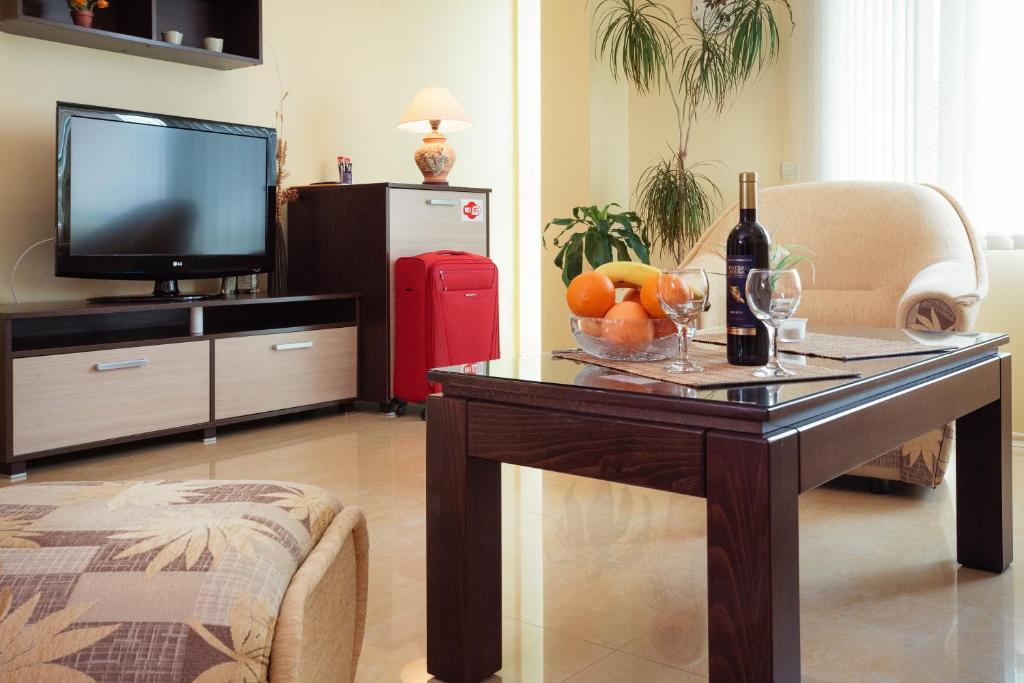 普羅夫迪夫的住宿－布萊特豪斯賓館，客厅配有桌子,提供一瓶葡萄酒和水果