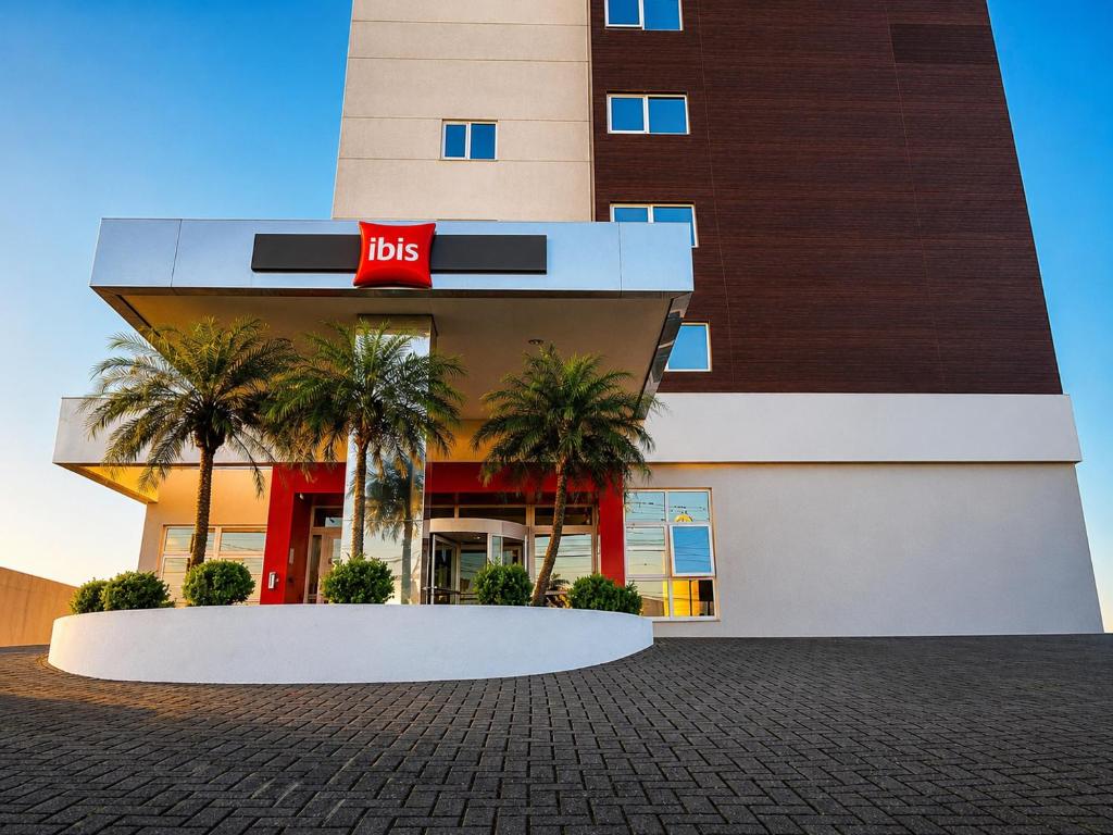 a hotel with palm trees in front of it at ibis Chapeco in Chapecó