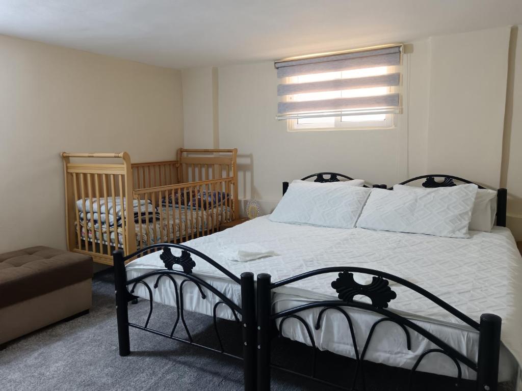 a bedroom with a bed with a crib and a window at Rousan House in Um Qeis