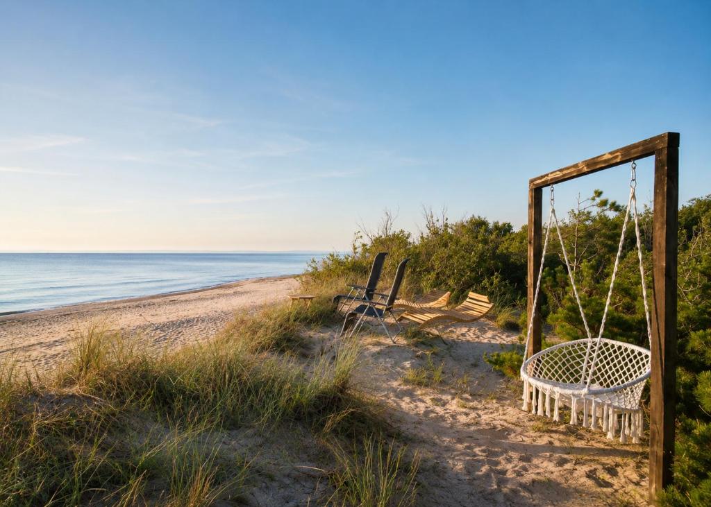 an old swing on a beach near the ocean at KOPA CABINS seaside stay in Nida