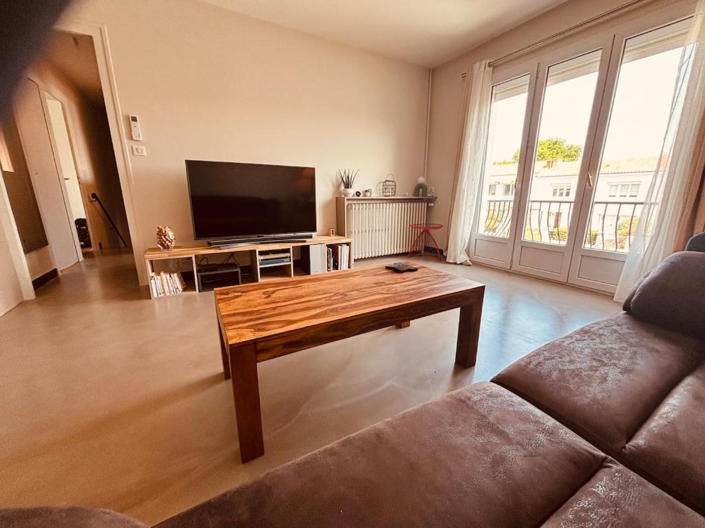 a living room with a coffee table and a flat screen tv at Belle maison hyper centrale 3 chambres in Lagord