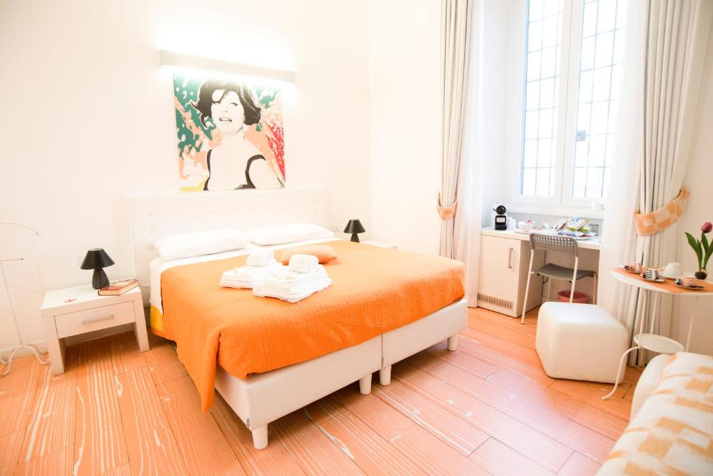 - une chambre avec un lit et une couverture orange dans l'établissement Divine Bed & Breakfast, à Rome
