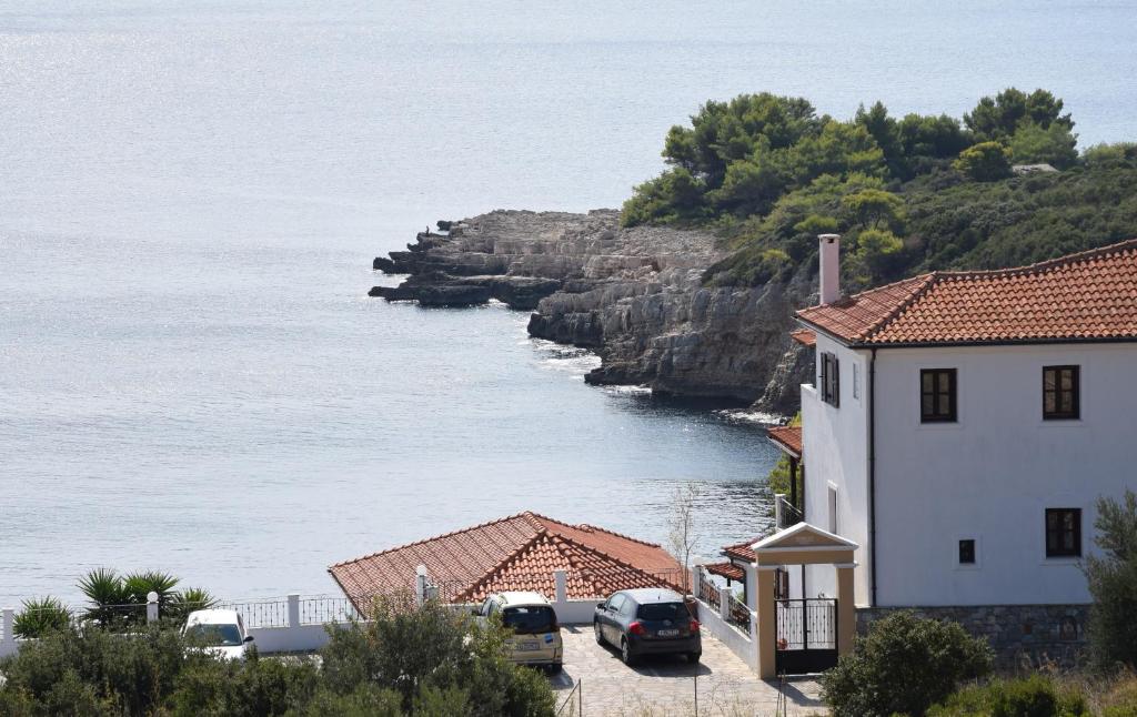 un grupo de edificios y coches estacionados junto al agua en Dimitra's Apartment en Votsi