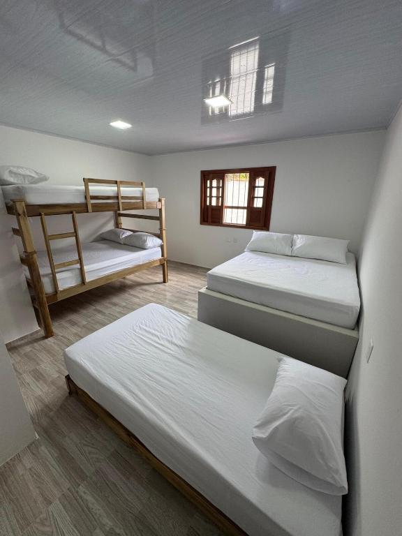 a room with two beds and a bunk bed at Sofi House Zap in Zapatoca