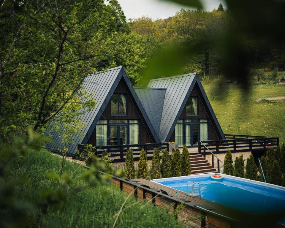 a house with a swimming pool in front of it at Shale Maidan in Maidan Village
