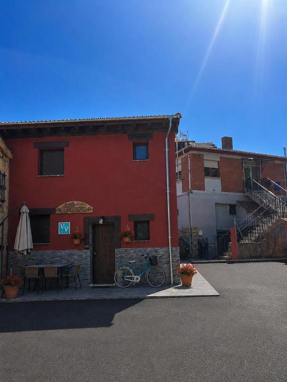 a red building with a bike parked in front of it at Ca el retriñon in Felechosa
