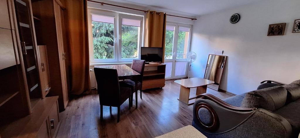a living room with a couch and a table with a desk at Przy rynku in Olecko