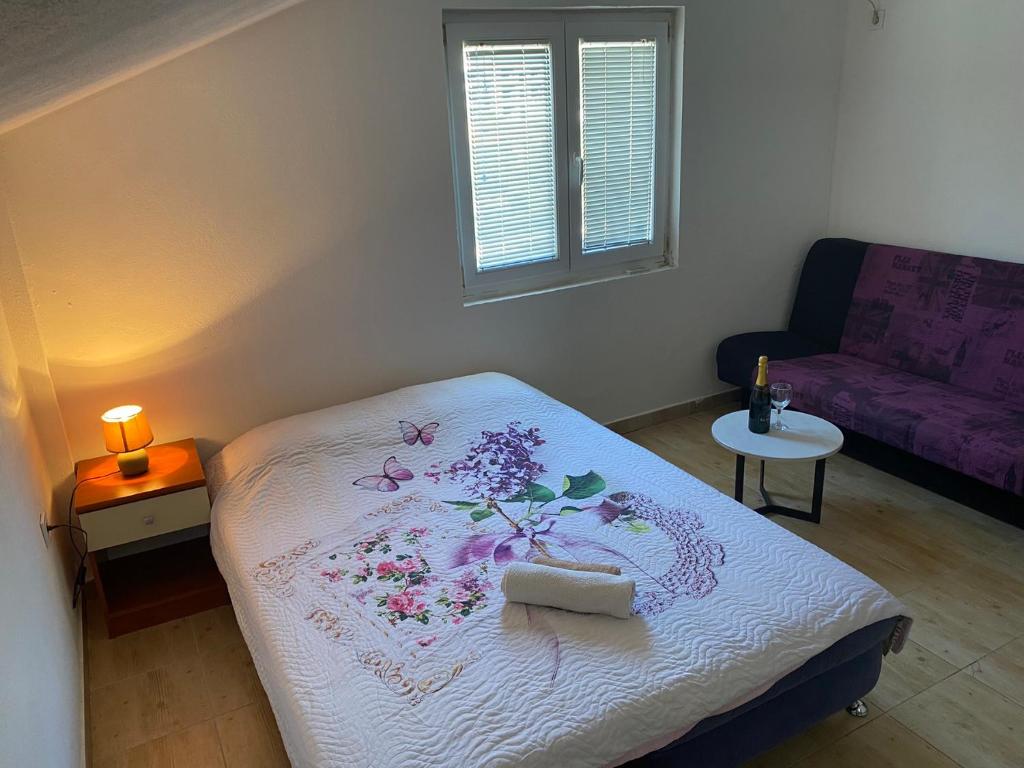 a small bedroom with a bed and a couch at Mia in Glavatske Kućice