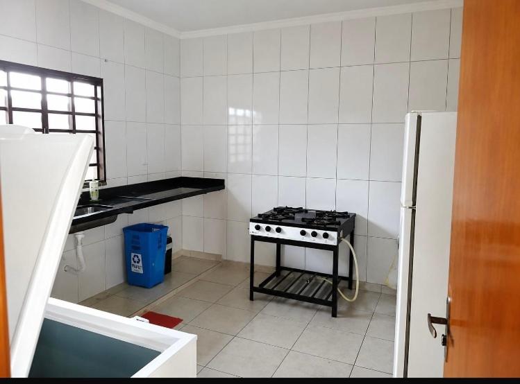 a kitchen with a stove and a refrigerator at Recanto sonho meu in Trindade