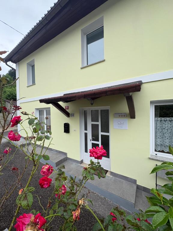 a house with red roses in front of it at Apartma Suzy in Bovec
