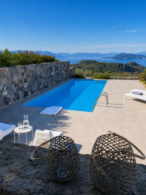 a villa with a swimming pool and a table and chairs at Óros Residence - Pool & Panoramic Views in Tzíkidhes