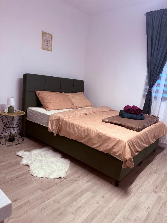 a bed sitting in a bedroom with a wooden floor at Studio Apartman Jovičić in Bjelovar