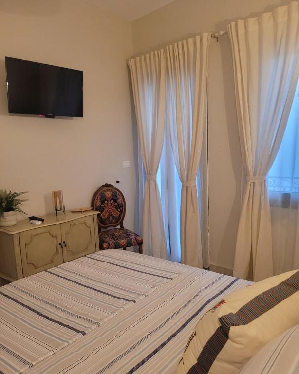 a bedroom with a bed and a television on the wall at City Center Suites in Karpathos