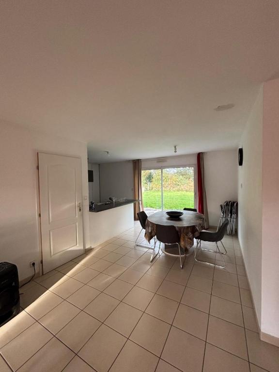 a room with a table and chairs and a window at Maison au calme in La Roche-sur-Yon
