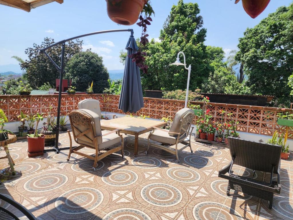 a patio with a table and chairs and an umbrella at Roof Garden 3 in Coatepec