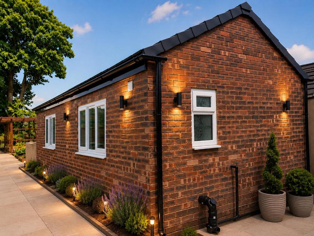 a brick house with lights on the side of it at The Annex EV 10 per night in Southport