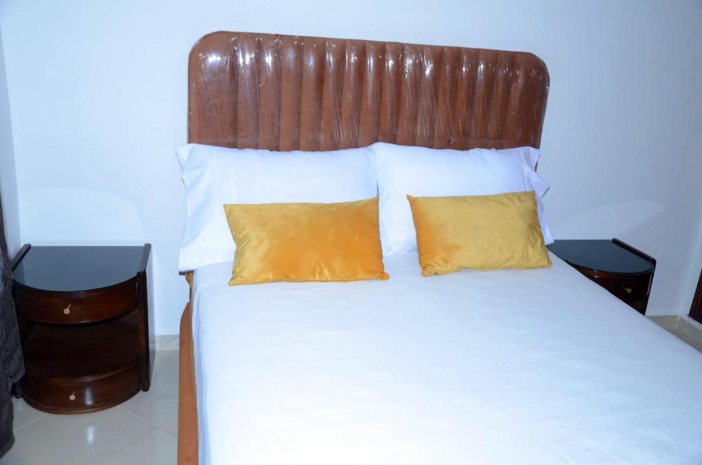 a bed with two pillows and a wooden headboard at إقامة جنان فاس in Fez