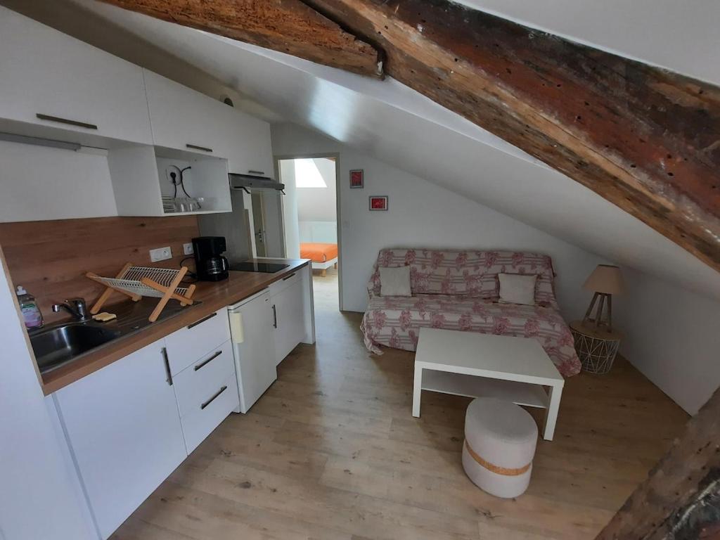 a kitchen and a living room with a couch and a table at Bords de Loire in Les Ponts-de-Cé